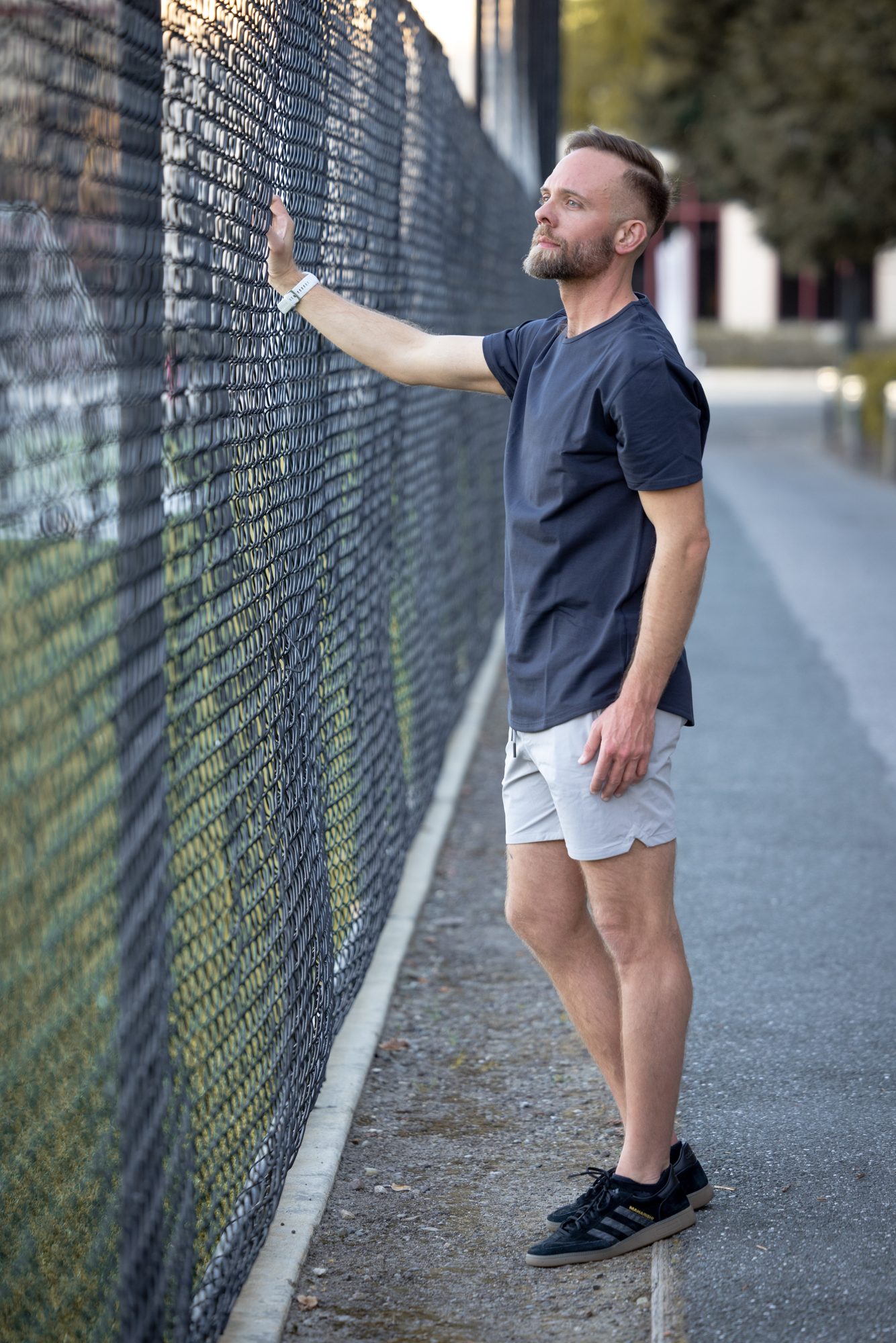 Bart leaning on a fence, looking up